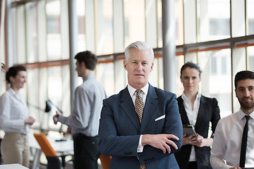 Image showing portrait of senior businessman as leader  with group of people i