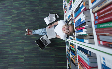 Image showing female student study in library, using tablet and searching for 