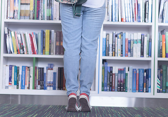 Image showing famale student selecting book to read in library