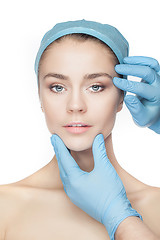 Image showing Plastic surgery concept. Doctor hands in gloves touching woman face