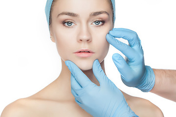 Image showing Plastic surgery concept. Doctor hands in gloves touching woman face