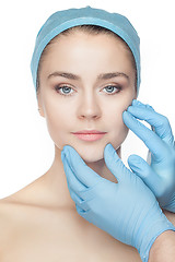 Image showing Plastic surgery concept. Doctor hands in gloves touching woman face