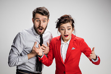 Image showing The surprised business man and woman smiling on a gray background