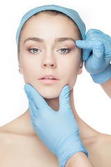 Image showing Plastic surgery concept. Doctor hands in gloves touching woman face