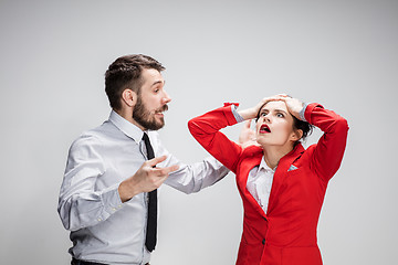 Image showing The business man and woman conflicting on a gray background