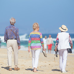 Image showing Active seniors enjoying beach walk.