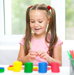 Image showing Little girl is playing with plasticine