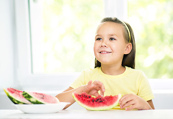 Image showing Cute little girl is eating watermelon