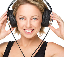 Image showing Young woman enjoying music using headphones