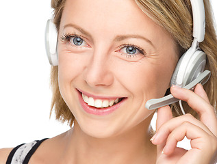 Image showing Lovely young woman is talking to customers