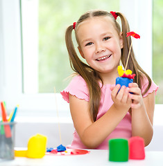 Image showing Little girl is playing with plasticine