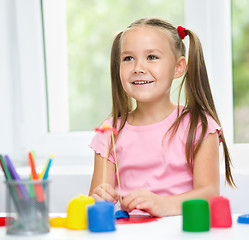 Image showing Girl is having fun while playing with plasticine