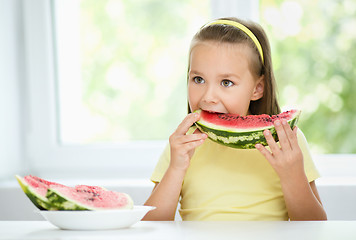 Image showing Cute little girl is eating watermelon