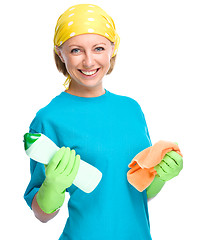 Image showing Young woman with cleaning liquid and rag