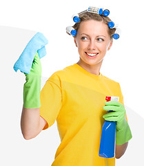 Image showing Young woman is cleaning glass using rag