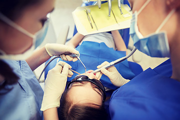 Image showing female dentists treating patient girl teeth