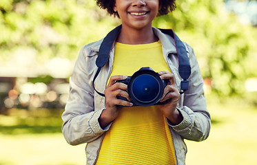 Image showing happy african woman with digital camera in park