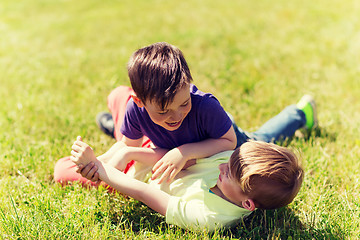 Image showing happy little boys fighting for fun on grass