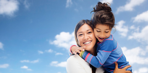 Image showing hugging mother and daughter over sky background