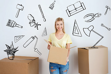 Image showing smiling young woman with cardboard box at home