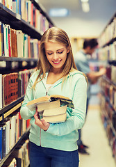 Image showing happy student girl or woman with book in library