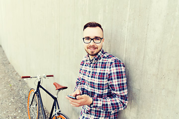 Image showing hipster man in earphones with smartphone and bike