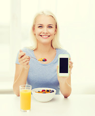 Image showing smiling woman with smartphone eating  breakfast 