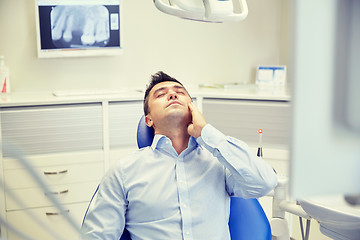 Image showing man having toothache and sitting on dental chair