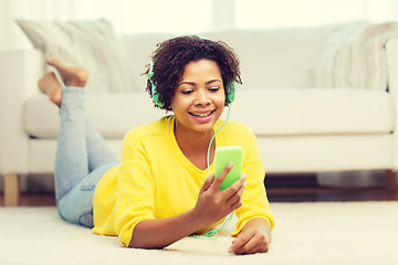 Image showing happy african woman with smartphone and headphones