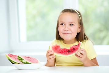 Image showing Cute little girl is eating watermelon