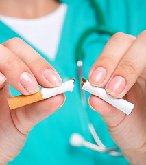 Image showing Doctor in uniform breaks cigarette