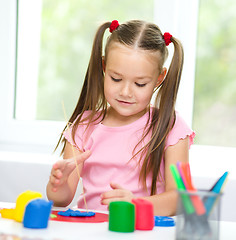 Image showing Little girl is playing with plasticine