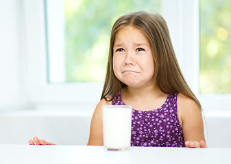 Image showing Sad little girl with a glass of milk