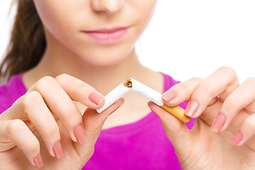 Image showing Young woman is breaking a cigarette