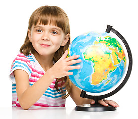 Image showing Little girl is examining globe