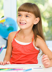 Image showing Little girl is drawing using pencils