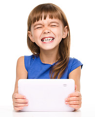 Image showing Young cheerful girl is using tablet