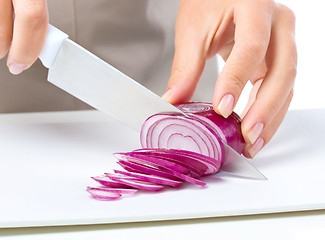 Image showing Cook is chopping onion