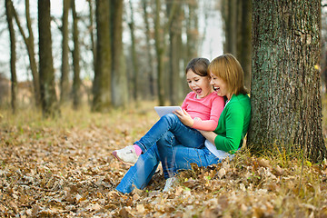 Image showing Mother and her daughter is playing with tablet