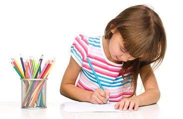 Image showing Little girl is drawing using pencils