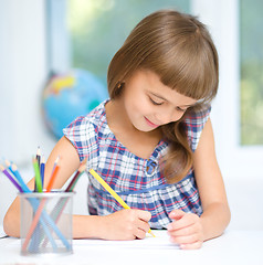 Image showing Little girl is drawing using pencils