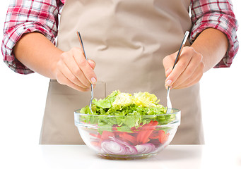 Image showing Cook is mixing salad