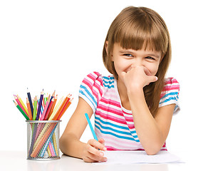 Image showing Little girl is drawing using pencils