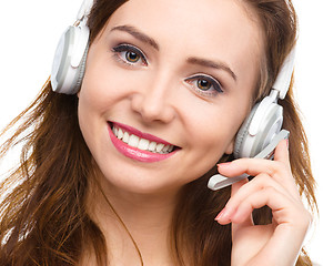 Image showing Lovely young woman is talking to customers