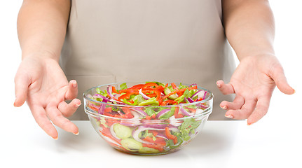 Image showing Cook is presenting fresh salad