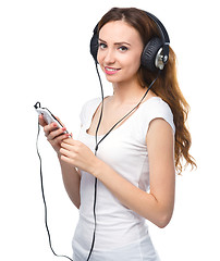 Image showing Young woman enjoying music using headphones