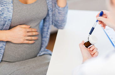 Image showing close up of doctor showing pills to pregnant woman