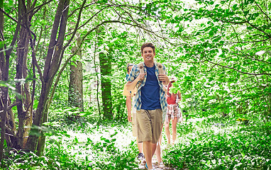 Image showing group of smiling friends with backpacks hiking