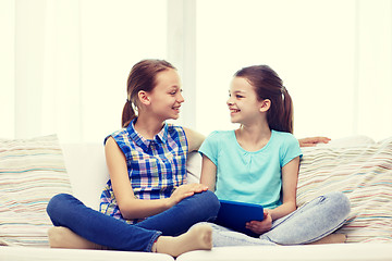 Image showing happy girls with tablet pc talking at home