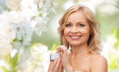 Image showing happy woman with cream jar